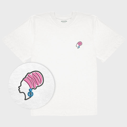 Unisex-T-Shirt Oversize weiß mit bestickter Brustpartie, Fokus auf Design, afrikanischer Frau mit Kopftuch und großen Ohrringen