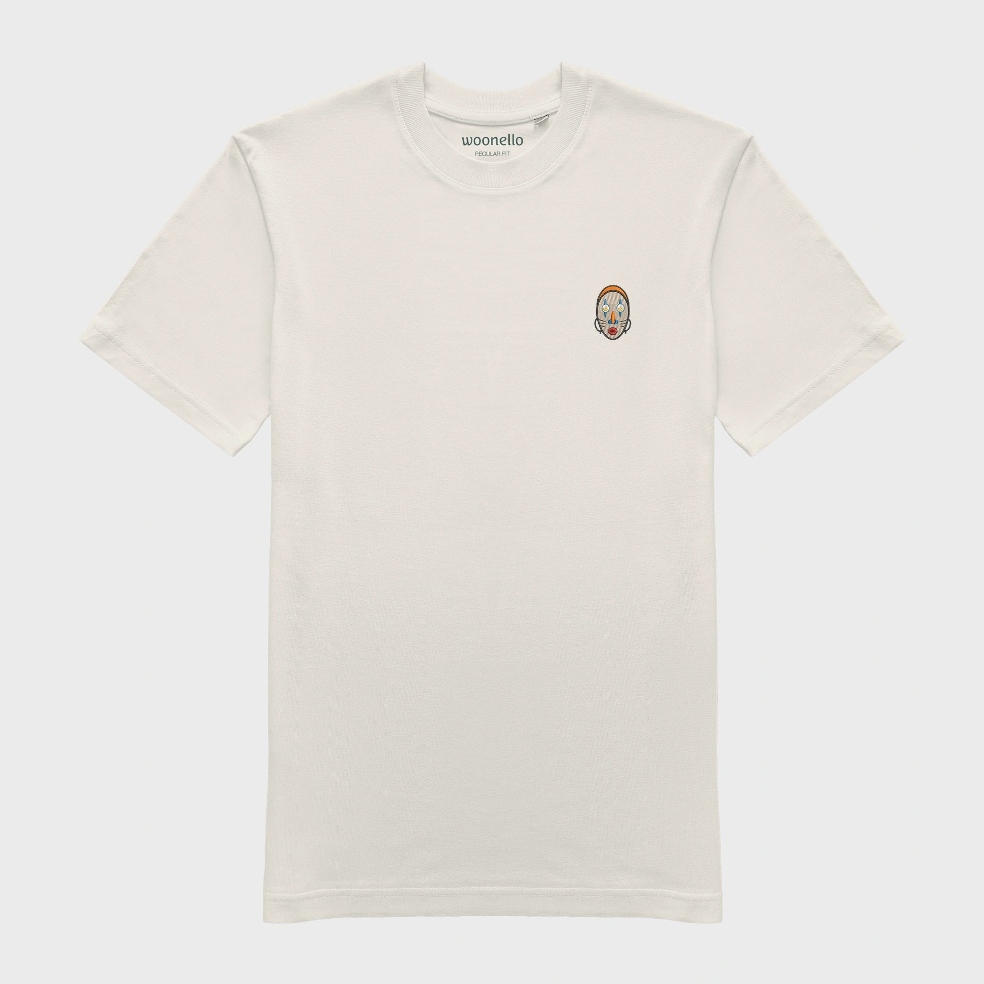 Unisex-T-Shirt cremeweiß mit bestickter Brustpartie, abstraktes afrikanisches Maske mit halbmondförmigen Augen