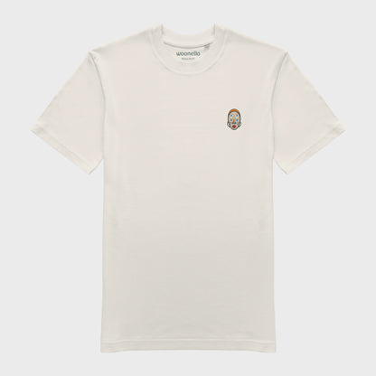 Unisex-T-Shirt cremeweiß mit bestickter Brustpartie, abstraktes afrikanisches Maske mit halbmondförmigen Augen