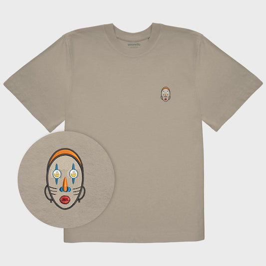 Unisex oversize mastic T-shirt with embroidered chest design, focus on design, Abstract African mask with crescent-shaped eyes