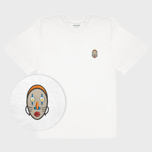 Unisex oversize white T-shirt with embroidered chest design, focus on design, Abstract African mask with crescent-shaped eyes